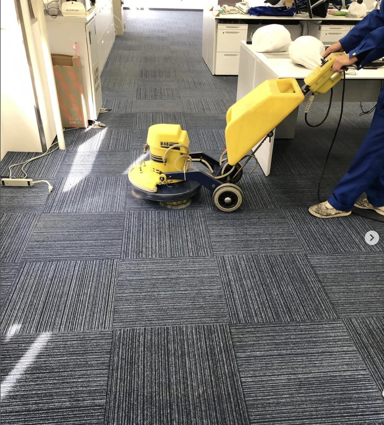 専用機械でカーペットを洗浄する作業