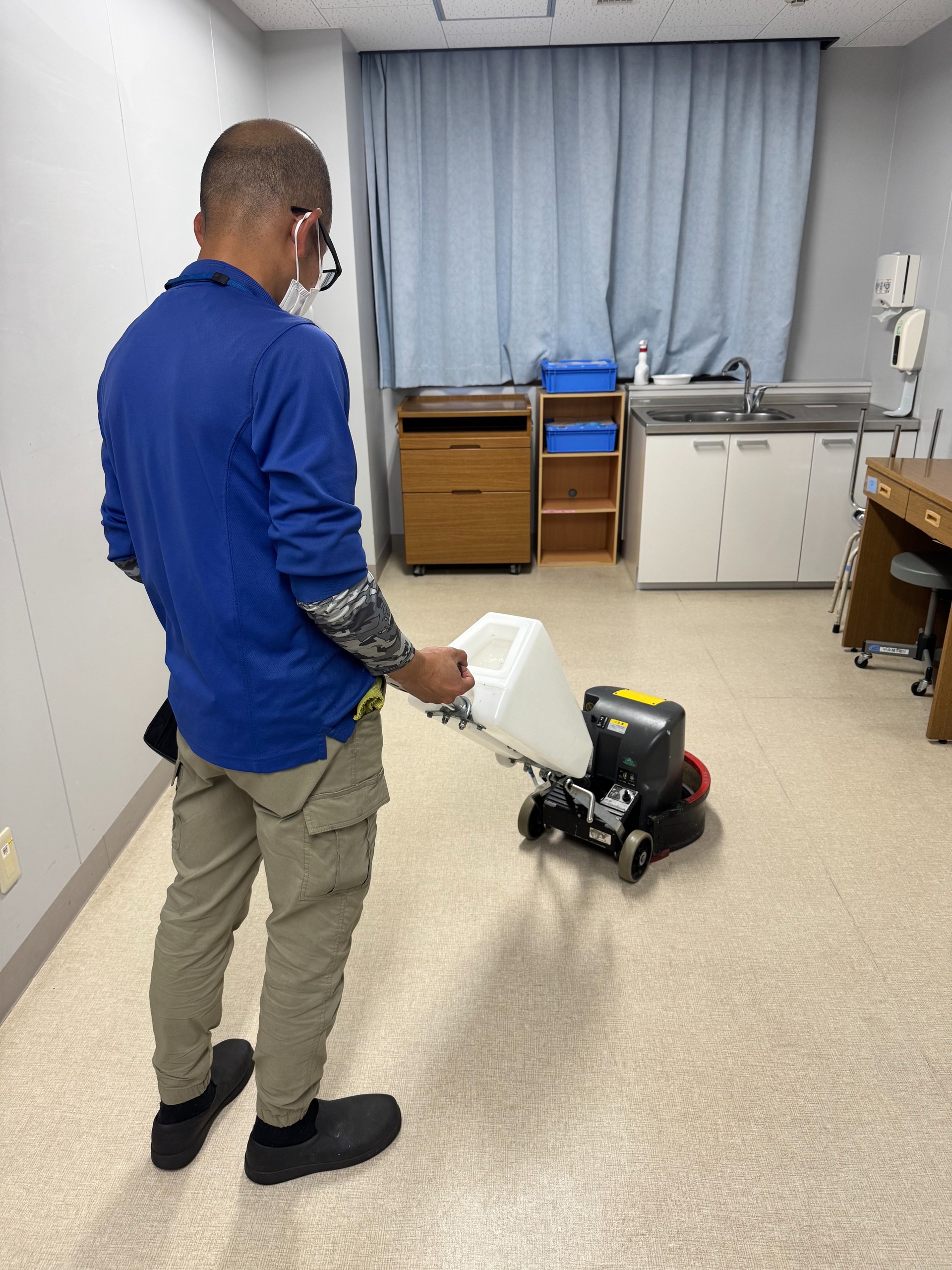自動床洗浄機を使用して床を清掃するスタッフ